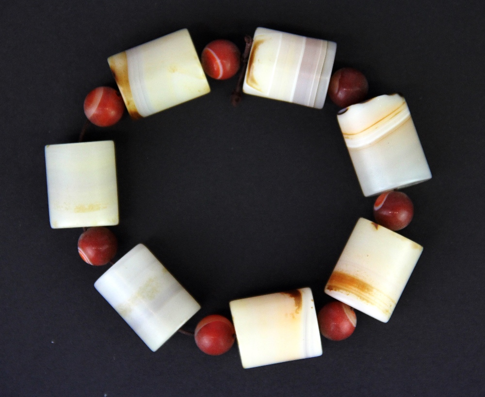 A group of banded agate beads currently loosley threaded as a bracelet, bead size H. 2.8cm, L. 2.