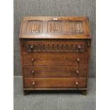 An oak linen fold drop front bureau, W. 76cm H. 92cm.