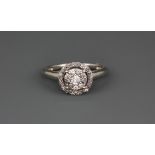 A 9ct white gold (stamped 375) halo ring set with brilliant cut diamonds, (M).