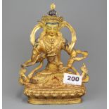 A Tibetan gilt bronze figure of a seated Tara with hand painted face and holding a Doje, H. 20cm.