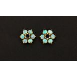 A pair of hallmarked 9ct gold cluster earrings set with cabochon cut opals and a round cut sapphire,
