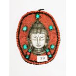 A Tibetan cast steel Buddha head mounted in beadwork, H. 21cm.