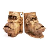 An interesting pair of carved wooden monkey head bookends, H. 20cm.