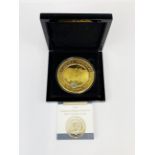 A cased proof ten ounce ten crown coin layered in 24ct gold with rhodium platinum accents.