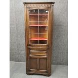 A lead glazed oak linenfold corner cabinet, H. 173cm W. 62cm.