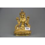 A Tibetan gilt bronze figure of a seated Tara with a hand painted face, H. 20cm.