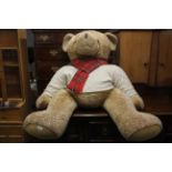 A very large Harrods stuffed teddy bear, H. 120cm W. 100cm.