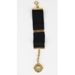 A 9ct gold Masonic watch thob, approx 11g with ribbon.