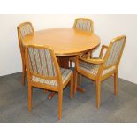A 1970's style circular extending teak dining table and four chairs.