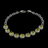 A matching 925 silver bracelet set with round cut peridots and white stones, L. 18cm.