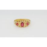 An antique hallmarked 18ct yellow gold ring set with oval cut rubies and diamonds, (P).