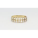 A yellow metal (tested minimum 9ct gold) ring set with a double row of white stones, (P).