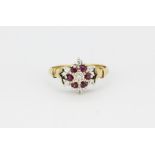 A hallmarked 9ct yellow gold cluster ring set with brilliant cut diamonds and rubies, (O.5).