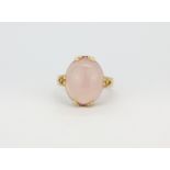 A 14ct yellow gold (stamped 14k) ring set with an oval cabochon cut rose quartz, (M.5).