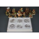A group of Hummel figurines, together with a Black Forest figure of a boy with a dog and a box of
