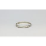 A white metal (tested 14ct gold) half eternity ring set with diamonds, (U).