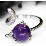 A 925 silver adjustable ring set with a cabochon cut amethyst and white stones.