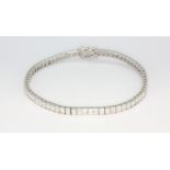 An 18ct white gold line bracelet set with princess cut diamonds, approx 6.66ct overall, approx. L.