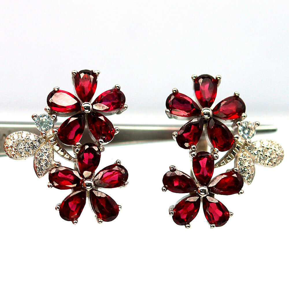 A pair of 925 silver garnet set flower shaped drop earrings, L. 2cm.