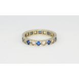 A hallmarked 9ct white gold eternity ring set with round cut synthetic spinels, (Q).