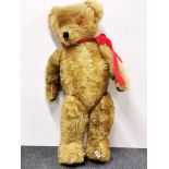 A large straw filled articulated teddy bear, H. 95cm.