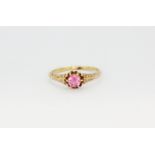 A 14ct yellow gold (stamped 14k) solitaire ring set with a round cut pink topaz, (O.5).