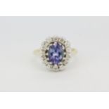 A hallmarked 18ct yellow and white gold cluster ring set with a large oval cut tanzanite