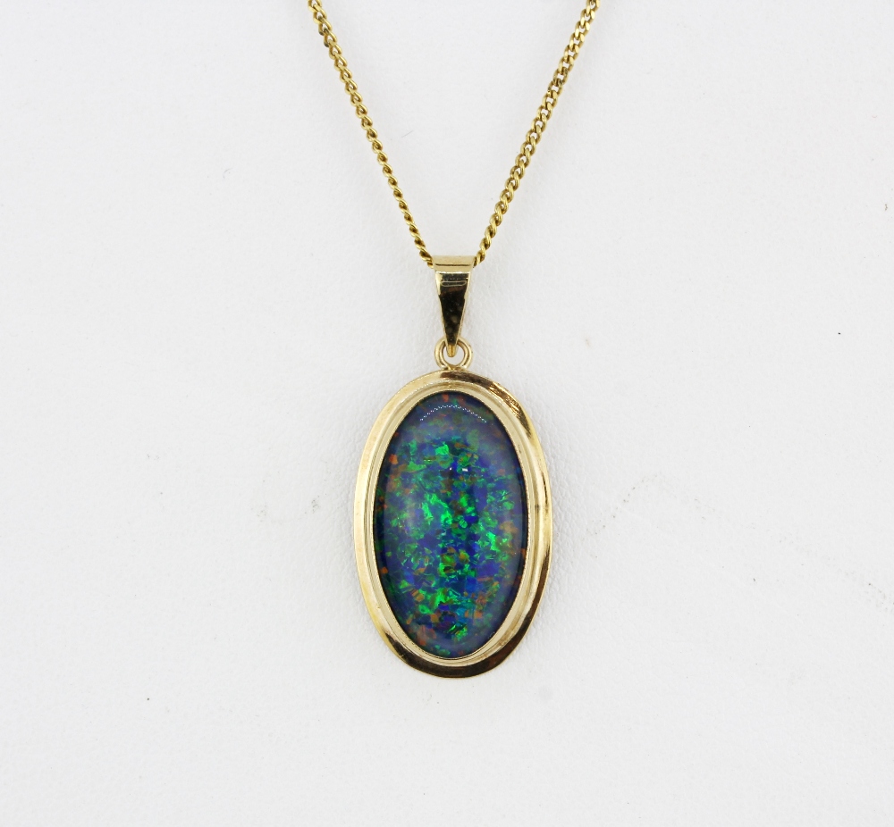 A large 9ct yellow gold (stamped 375) opal triplet set pendant (L.3cm) on a 9ct yellow gold chain,