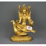 An unusual Tibetan gilt bronze figure of a four arm Tara seated on a bird, H. 25cm.