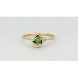 A 9ct yellow gold ring set with a round cut emerald and diamonds, (P), approx. 1.3gr.