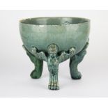 An unusual early glazed pottery bowl mounted on three cherub head and lion foot supports, Dia. 13.5,