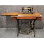 A vintage treddle sewing machine with cast iren frame, table H. 75cm extended W. 122cm.