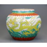 A Chinese hand painted porcelain jar with lid, decorated with two yellow dragons flying over