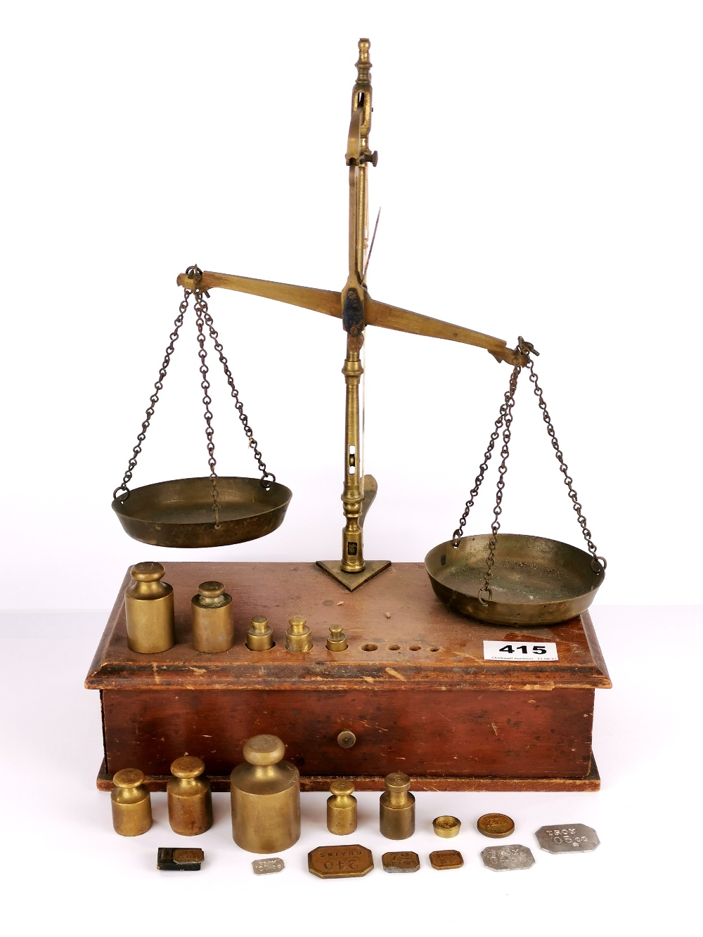 A mahogany and brass balance scale with a good selection of weights.