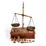 A mahogany and brass balance scale with a good selection of weights.