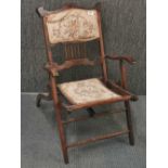 An upholstered folding campaign chair, H. 80cm.