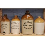 Four large stoneware advertising bottles, largest H.43cm.