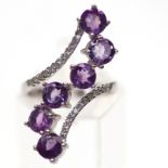 A 925 silver amethyst and white stone set crossover ring, (M).