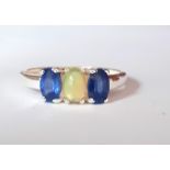 A 925 silver ring set with a cabochon cut opal flanked by oval cut sapphires, (P.5).