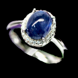 A 925 silver cluster ring set with cabochon cut sapphire surrounded by white stones, (P.5).
