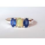 A 925 silver ring set with a cabochon cut opal flanked by oval cut sapphires, (P.5).