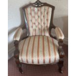 A Victorian upholstered carved mahogany arm chair.