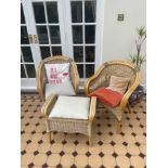 A pair of cane arm chairs and a footstool.