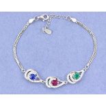 A 925 silver bracelet set with oval cut emerald, ruby and sapphire surrounded by white stones, L.