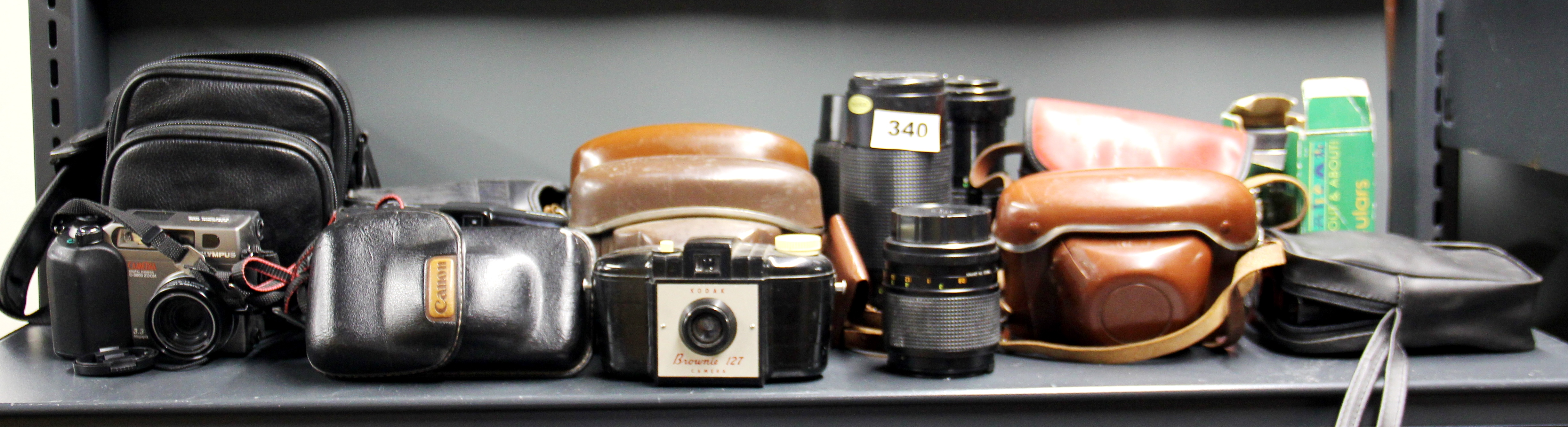 A group of mixed cameras and lenses.