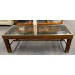A 1970's brass edged mahogany coffee table inset with a medieval battle scene, 107 x 46 x 35cm.