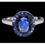 A 925 silver cluster ring set with oval cut opal and two rows of sapphires, (P).