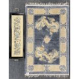 A small Chinese washed wool rug together with a tea tray inset with a Chinese hand embroidered panel