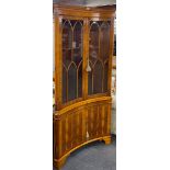 An unusual good quality yew wood veneered concaved corner cabinet, W. 91cm. H. 189cm.