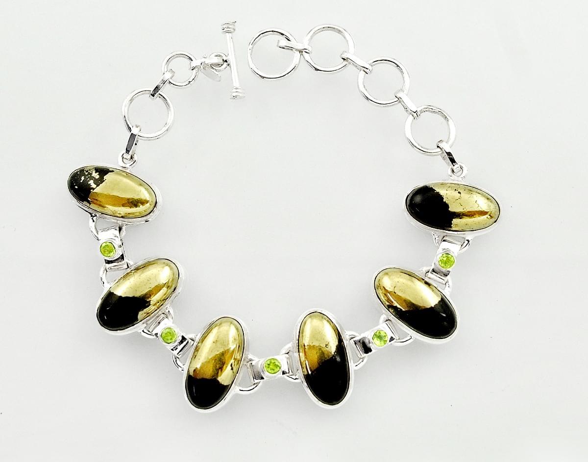 A 925 silver bracelet set with pyrite into magnetite and peridots, L. 21cm.